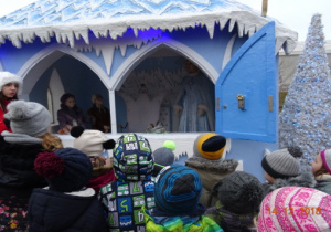 Dzieci stoją przed domkiem Królowej Śniegu.